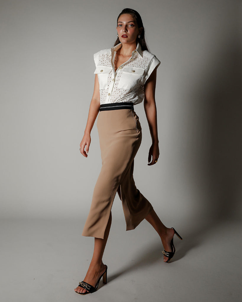Model wearing the Aura State Shirt in cotton embroidered anglaise with contrast cotton sateen detailing, styled with a camel midi skirt for Realm Origin's New Arrivals banner.